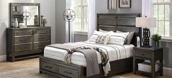 A bedroom set with a bed, dresser and mirror.