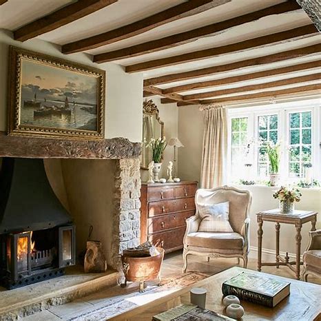 A living room with a stone fireplace and wooden beams.