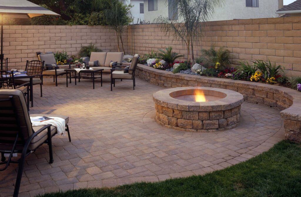 A patio with a fire pit and patio furniture.