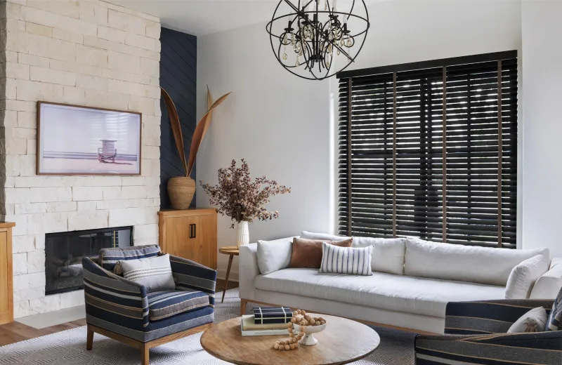 A living room with a fireplace and white furniture.