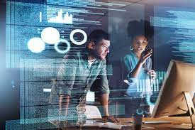 A man and woman looking at a computer screen.