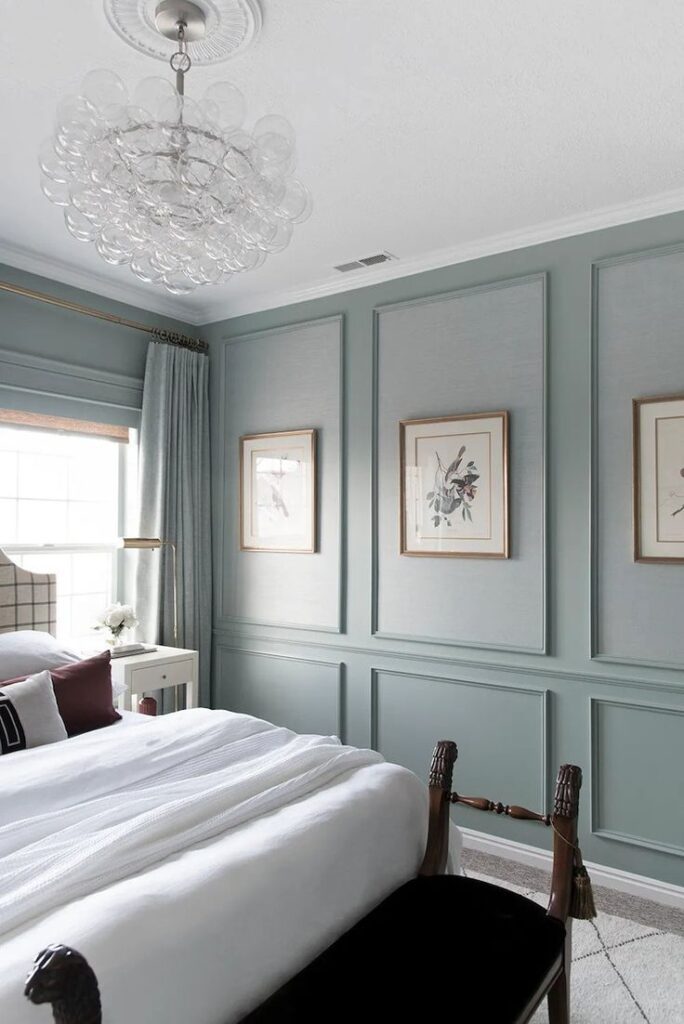 A bedroom with blue walls and a chandelier.